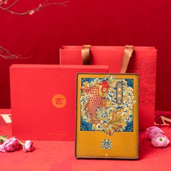 Red festive scene with a gold-accented tin featuring a colorful koi fish in front of a red gift box and red bag with gold handles.