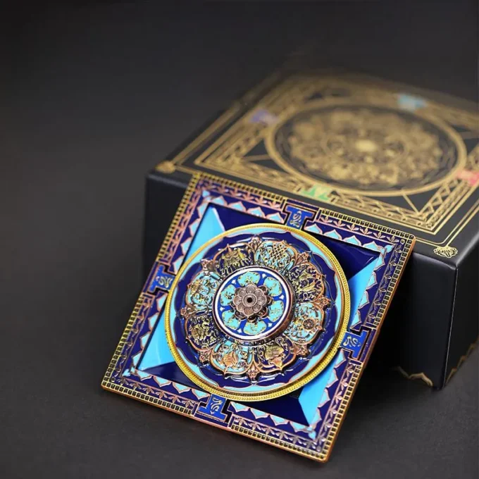 Decorative square card with a turquoise and gold mandala motif beside a black ornate box.